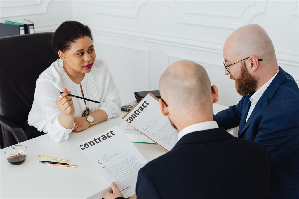 Koper en adviseurs bespreken de stukken tijdens een due diligence onderzoek